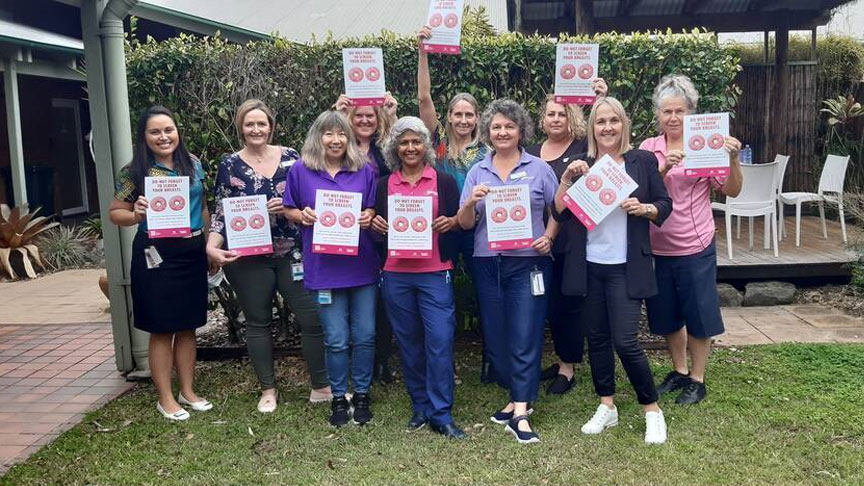 The team at BreastScreen Queensland Sunshine Coast holding posters with the message 'Do-nut forget to screen your breasts' 