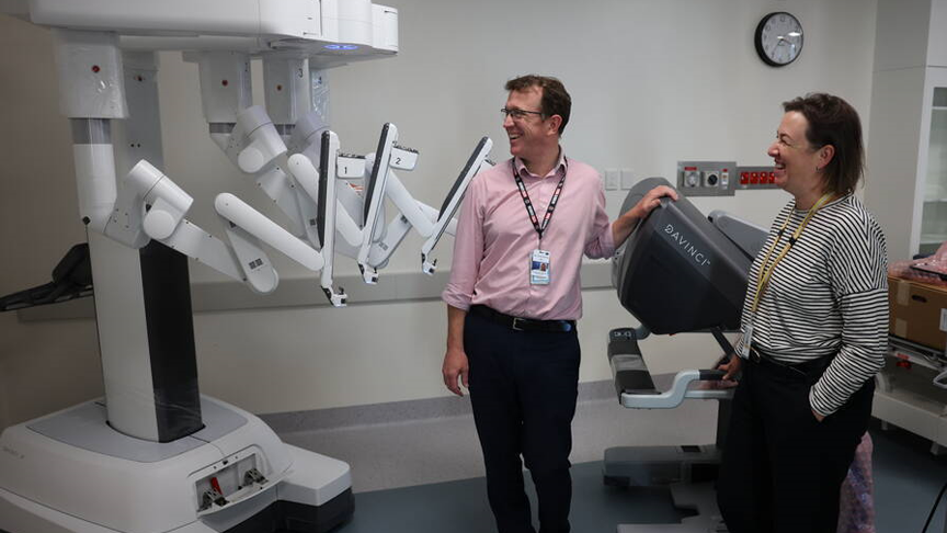 Two people stand and look at the Da Vinci Robot in Sunshine Coast University Hospital