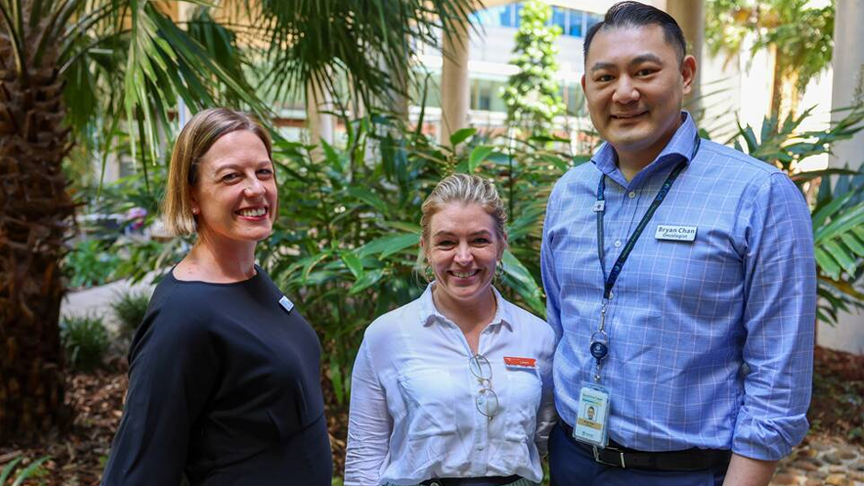 Three members of the Cancer Care team stand in the courtyard outside Sunshine Coast University Hospital